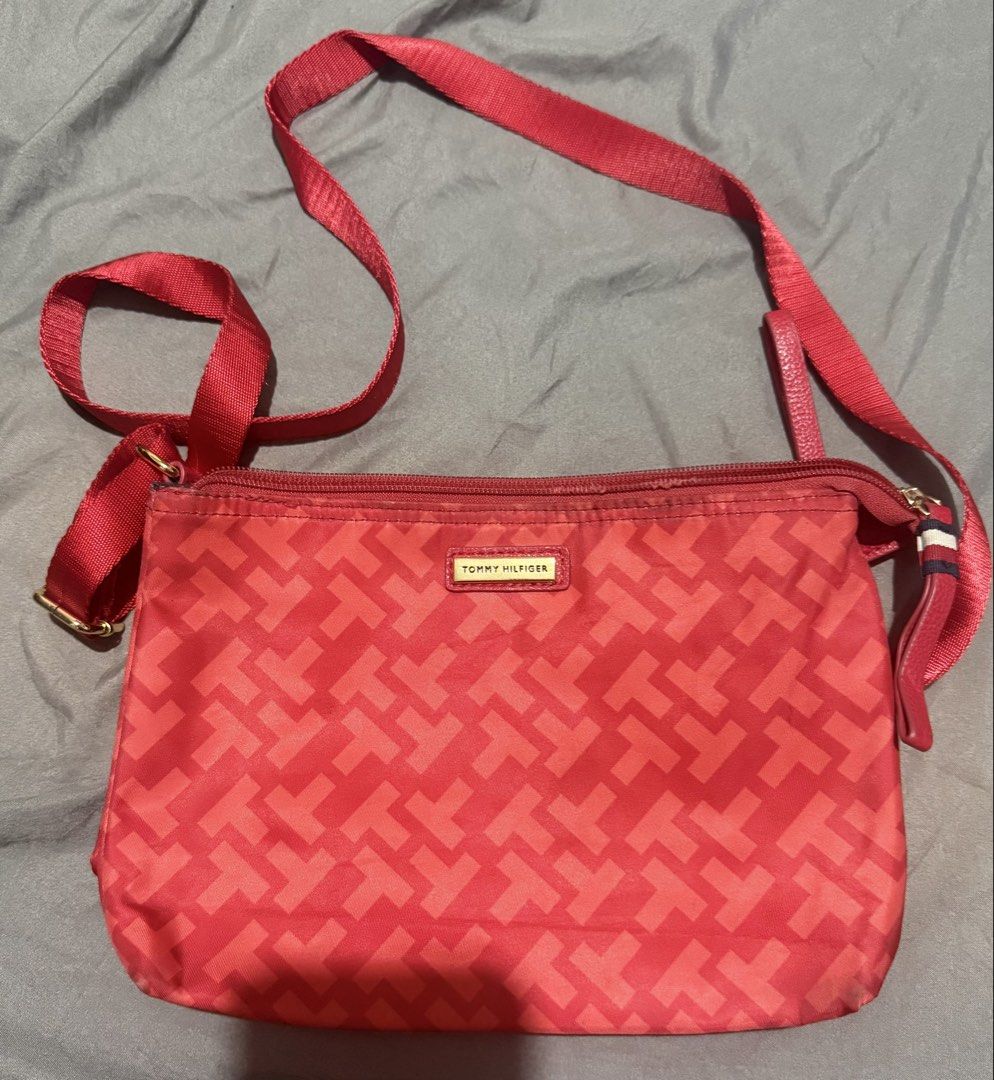 Tommy Hilfiger Red Monogram Crossbody Bag (Category: Cross-body Bags) located in Cainta. Submitted by mykee1 (Listing ID 1469228719, Image 1). Description: - Brand: Tommy Hilfiger - Style: Crossbody bag - Color: Red with all-over T monogram pattern - Material: Durable nylon - Hardware: Gold-tone logo plaque on the front - Closure: Secure zip-top - Strap: Adjustable fabric shoulder strap - Accent: Small side tab featuring the signature red, white,