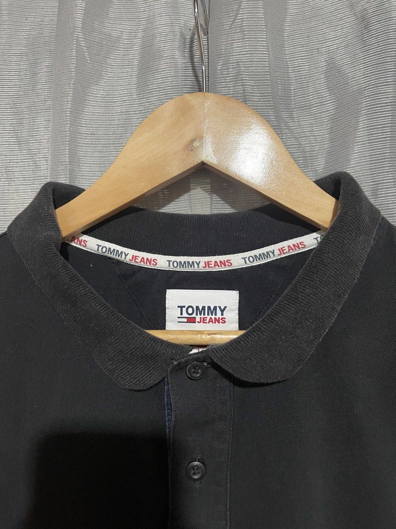 Tommy Jeans Black Polo Shirt (Category: Tshirts & Polo Shirts ) located in Calbayog City. Submitted by thriftme.bro (Listing ID 1469324470, Image 3). Description: Tommy Jeans black polo shirt with a classic collar and short sleeves. Features a two-button placket and branded inner collar tape. Small embroidered logo patch on the left chest. Ribbed cuffs and side hem slits. Made from soft cotton blend fabric. Clean look, goes with everything..