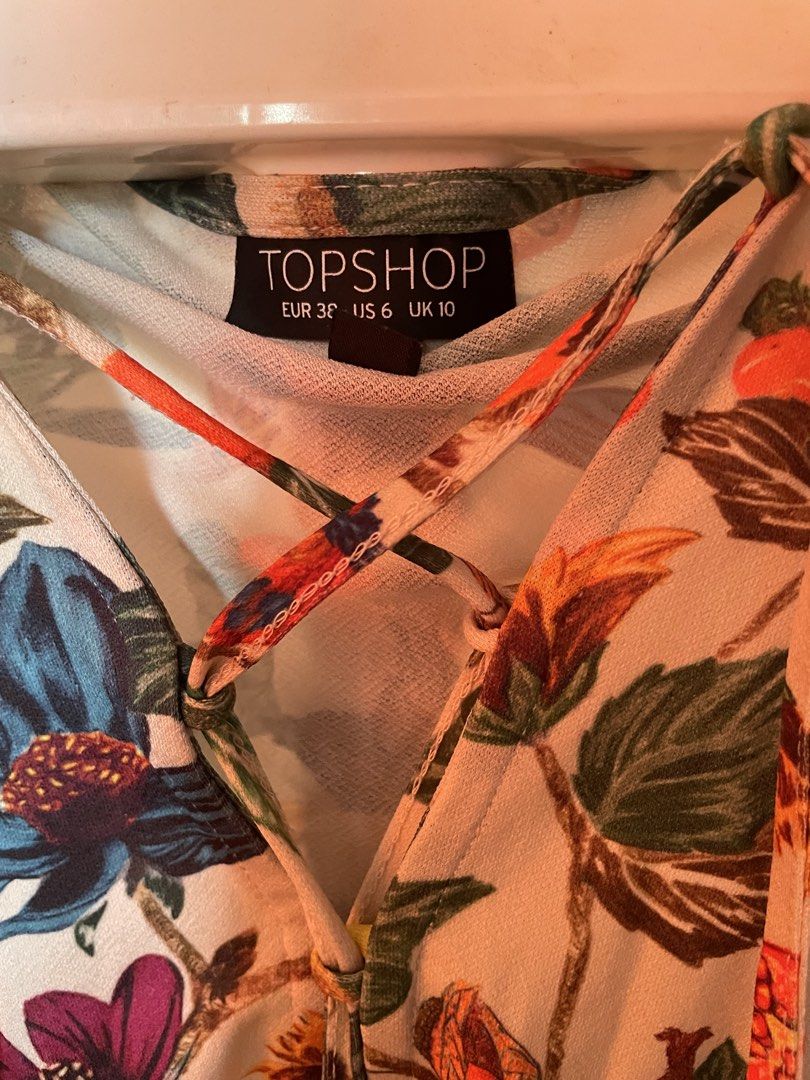 Topshop Floral Print romper (Category: Dresses) located in Manila. Submitted by zzjjm (Listing ID 1469222777, Image 2). Description: - Brand: Topshop - Size: EUR 38 / US 6 / UK 10 - Design: Colorful floral and botanical print - Details: Long sleeves, V-neckline with lace-up criss-cross ties, and elasticated waist for a flattering fit - Fabric: Lightweight and comfortable - Condition: Great for casual days out or evening wear.