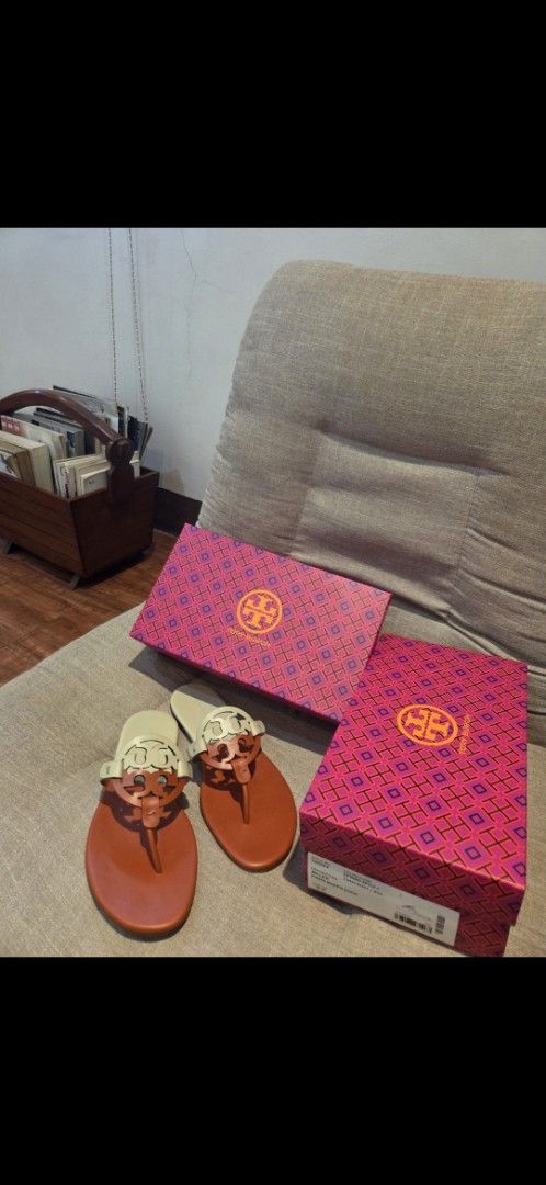 Tory Burch Miller Sandals with Box (Category: Flats & Sandals) located in Manila. Submitted by mysticrabbit.284012 (Listing ID 1469276115, Image 1). Description: - Brand: Tory Burch Miller Sandals - Color: Tan and White - Material: Premium Leather - Design: Iconic cutout logo, slip-on flat style - Comfort: Perfect for daily wear - Inclusions: Original pink patterned box included - Condition: Ready for your wardrobe!.