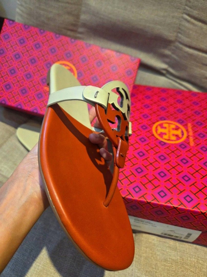 Tory Burch Miller Sandals with Box (Category: Flats & Sandals) located in Manila. Submitted by mysticrabbit.284012 (Listing ID 1469276115, Image 3). Description: - Brand: Tory Burch Miller Sandals - Color: Tan and White - Material: Premium Leather - Design: Iconic cutout logo, slip-on flat style - Comfort: Perfect for daily wear - Inclusions: Original pink patterned box included - Condition: Ready for your wardrobe!.