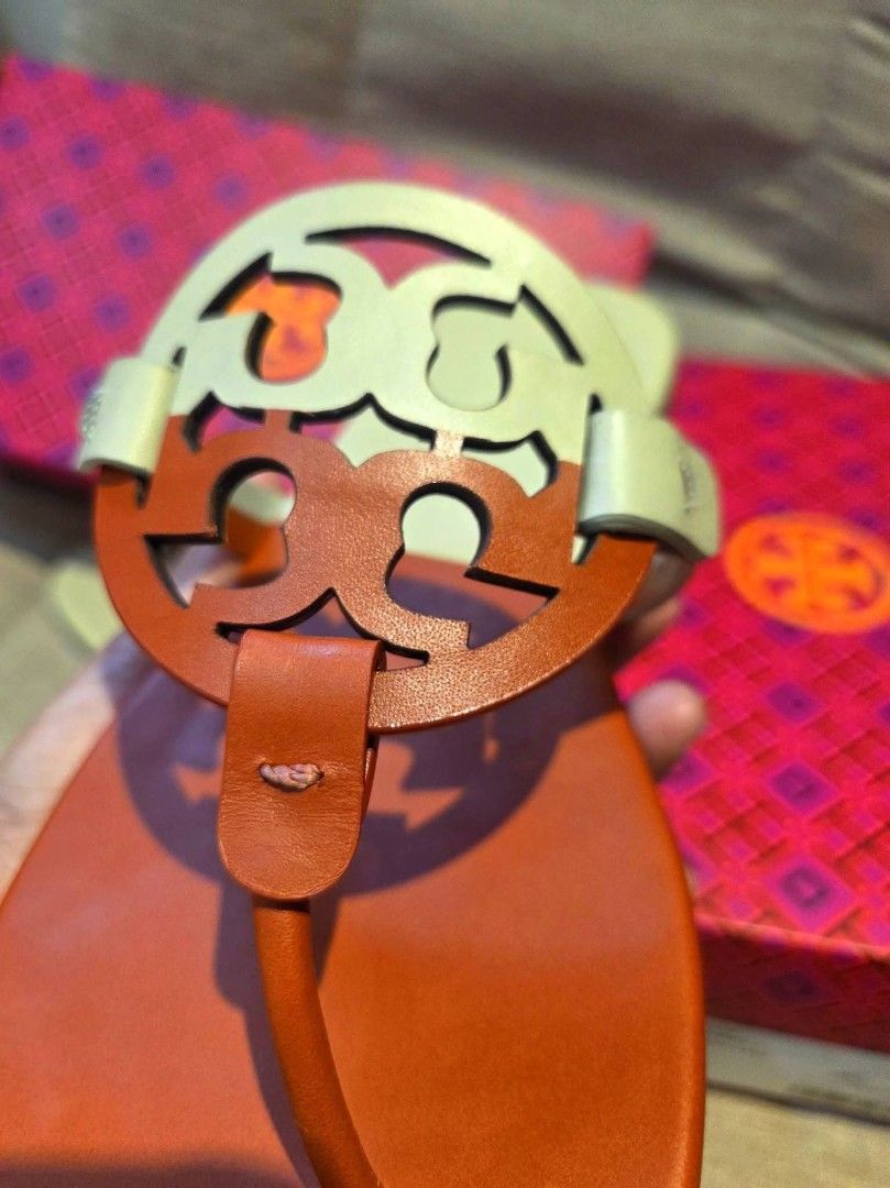Tory Burch Miller Sandals with Box (Category: Flats & Sandals) located in Manila. Submitted by mysticrabbit.284012 (Listing ID 1469276115, Image 2). Description: - Brand: Tory Burch Miller Sandals - Color: Tan and White - Material: Premium Leather - Design: Iconic cutout logo, slip-on flat style - Comfort: Perfect for daily wear - Inclusions: Original pink patterned box included - Condition: Ready for your wardrobe!.