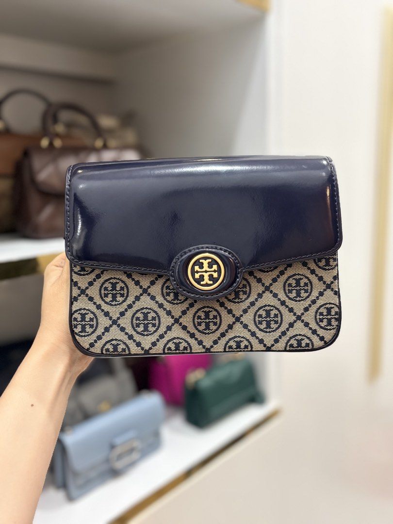Tory Burch Monogram Jacquard Shoulder Bag Navy Blue (Category: Shoulder Bags) located in Zamboanga. Submitted by khdjtuttoh (Listing ID 1469293864, Image 1). Description: - Brand: Tory Burch - Style: Monogram Jacquard Shoulder Bag - Color: Navy blue and beige with dark navy and brown leather accents - Hardware: Gold-tone - Closure: Magnetic snap under flap - Strap: Adjustable brown leather strap with gold studs - Interior: Light fabric lining wit