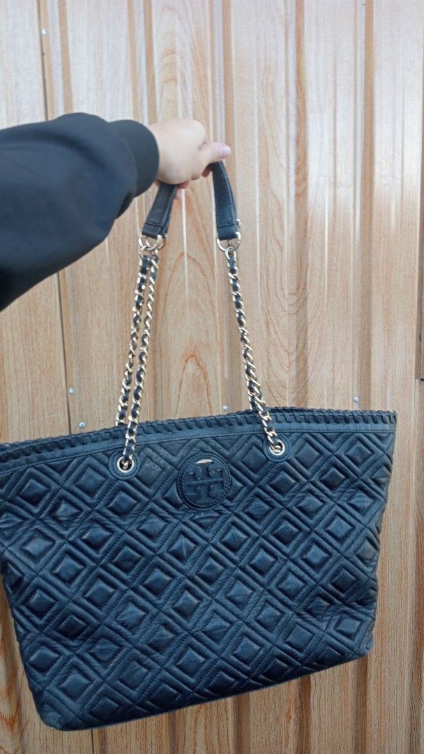 Tory Burch Quilted Black Leather Tote Bag (Category: Tote Bags) located in Cagayan de Oro. Submitted by zoe-ini (Listing ID 1469208001, Image 1). Description: - Brand: Tory Burch - Material: Genuine black leather with classic diamond quilting - Hardware: Gold-tone - Straps: Double chain and leather shoulder straps - Design: Iconic T logo stamped on the front - Storage: Spacious interior that easily fits daily essentials - Condition: Excellent eve