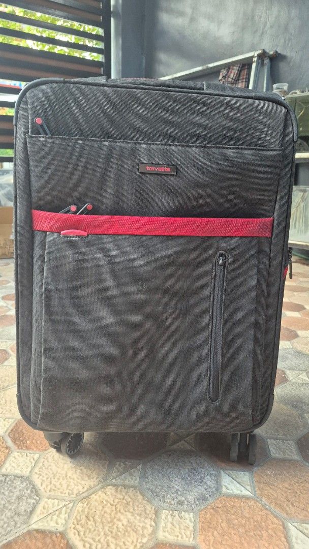 Travelite Softside Luggage (Category: Luggage) located in Imus. Submitted by erwin0000443 (Listing ID 1469239685, Image 1). Description: - Brand: Travelite - Color: Black with a red vertical stripe on the front pocket - Wheels: Smooth 360-degree double spinner wheels for effortless navigation - Security: Built in combination lock - Handles: Retractable telescopic top handle and comfortable side grab handle - Storage: Durable fabric construction f