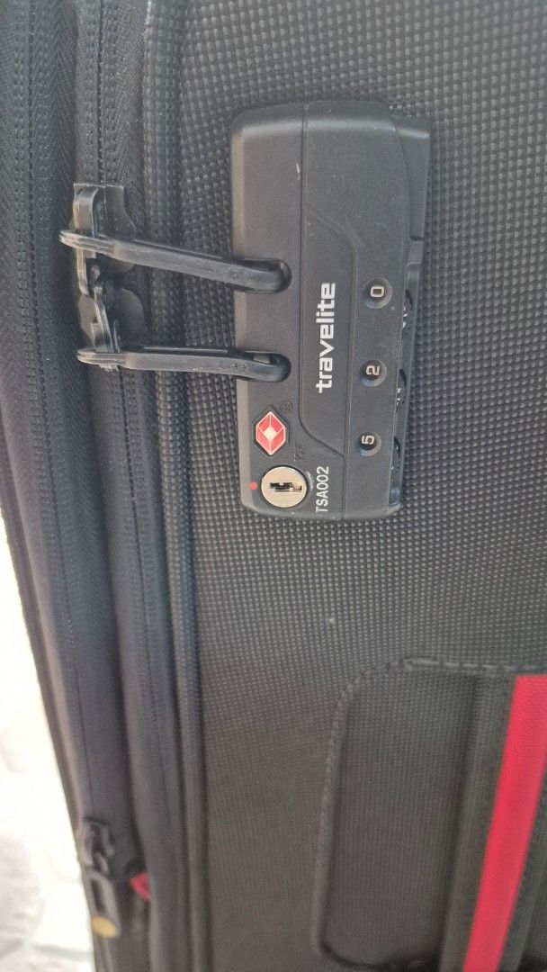 Travelite Softside Luggage (Category: Luggage) located in Imus. Submitted by erwin0000443 (Listing ID 1469239685, Image 3). Description: - Brand: Travelite - Color: Black with a red vertical stripe on the front pocket - Wheels: Smooth 360-degree double spinner wheels for effortless navigation - Security: Built in combination lock - Handles: Retractable telescopic top handle and comfortable side grab handle - Storage: Durable fabric construction f