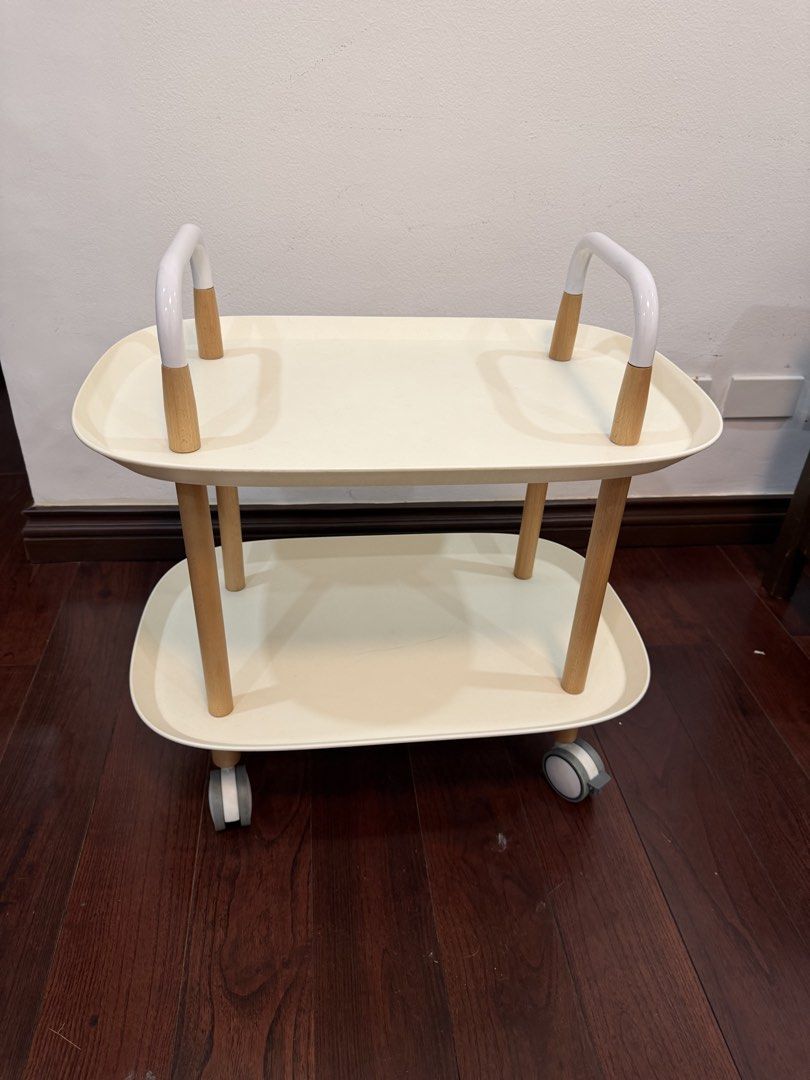 Two-Tier Rolling Utility Cart White and Wood (Category: Shelves, Cabinets & Racks) located in Makati City. Submitted by monkeykingo (Listing ID 1469257525, Image 1). Description: - Type: 2-Tier Rolling Utility Cart - Design: Modern white plastic trays with stylish wooden legs - Mobility: Features 4 caster wheels and dual top handles for easy steering - Condition: Clean surface, minimal wear - Usage: Versatile organizer for the kitchen, living roo