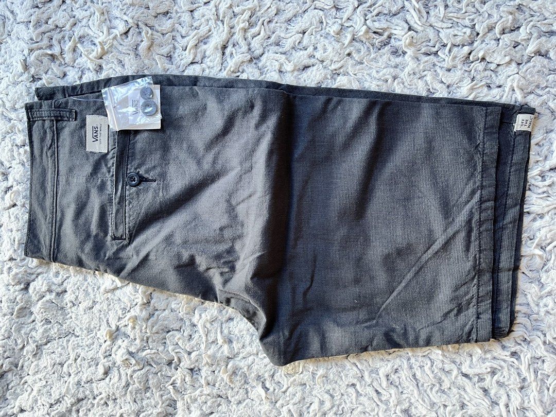 Vans dark grey patterned shorts size 30 (Category: Shorts) located in Adams. Submitted by m1k3yl (Listing ID 1469217055, Image 2). Description: - Brand: Vans - Condition: Brand new with store tags (Never worn) - Size: 30 - Color/Pattern: Dark grey with a subtle grid pattern - Details: Includes extra buttons in a small pouch, button-closure back pocket with Vans logo patch, and a Vans tag near the hem.