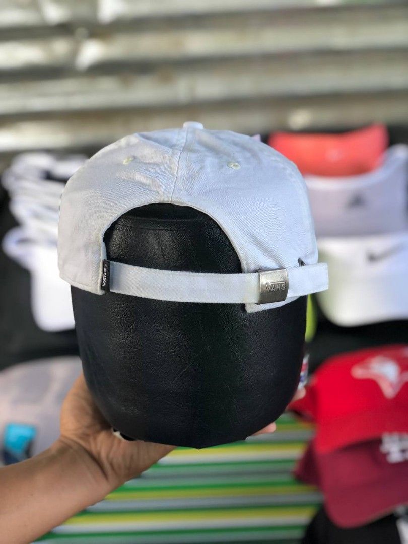 Vans White Baseball Cap with Checkerboard Logo (Category: Caps & Hats) located in Manila. Submitted by jowiegarci63146 (Listing ID 1469311228, Image 3). Description: - Color: Clean white - Design: Embroidered Vans text with stylish checkerboard pattern detail - Fit: Adjustable strap closure at the back with a branded metal buckle - Features: Curved brim, breathable eyelets, and small woven Vans label - Style: Versatile streetwear piece perfect fo