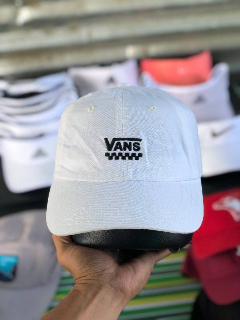 Vans White Baseball Cap with Checkerboard Logo (Category: Caps & Hats) located in Manila. Submitted by jowiegarci63146 (Listing ID 1469311228, Image 1). Description: - Color: Clean white - Design: Embroidered Vans text with stylish checkerboard pattern detail - Fit: Adjustable strap closure at the back with a branded metal buckle - Features: Curved brim, breathable eyelets, and small woven Vans label - Style: Versatile streetwear piece perfect fo