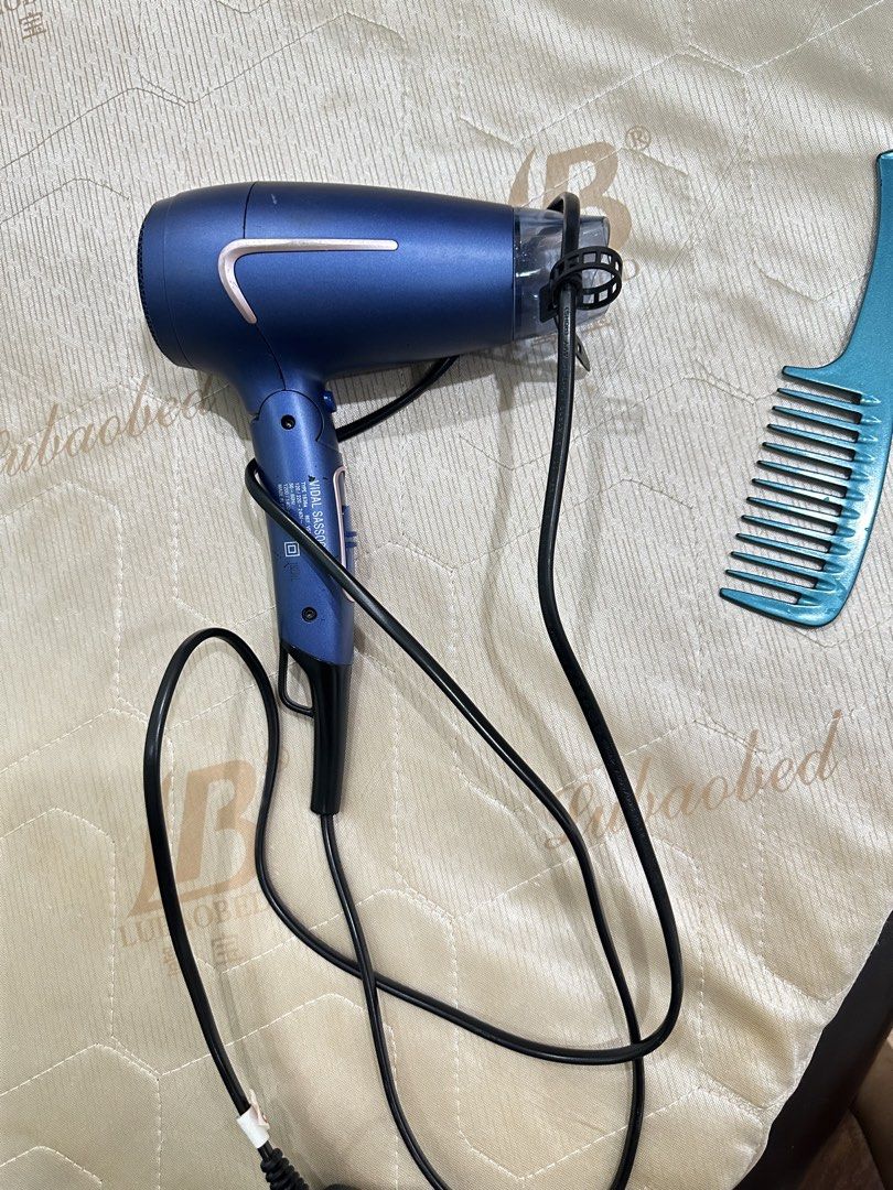 Vidal Sassoon Blue Hair Dryer (Category: Hair) located in San Juan City. Submitted by rose.lucky (Listing ID 1469202122, Image 3). Description: - Brand: Vidal Sassoon - Color: Blue - Condition: Working great, ideal for daily styling - Features: Standard handle design with convenient side control switches - Convenience: Built-in cord and plug for easy use and storage - Inclusion: Comes with a nozzle attachment.