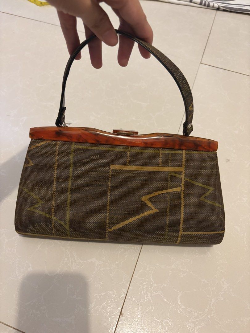 Vintage geometric pattern frame handbag (Category: Purses & Pouches) located in Las Pinas. Submitted by bibliomomma (Listing ID 1469241419, Image 1). Description: Chic vintage style kiss lock handbag featuring a brown geometric woven exterior and a striking faux tortoiseshell top frame. Opens up to a dark-lined interior with a zip compartment for securely organizing smaller essentials. Compact and structured with a single top handle, perfect for 