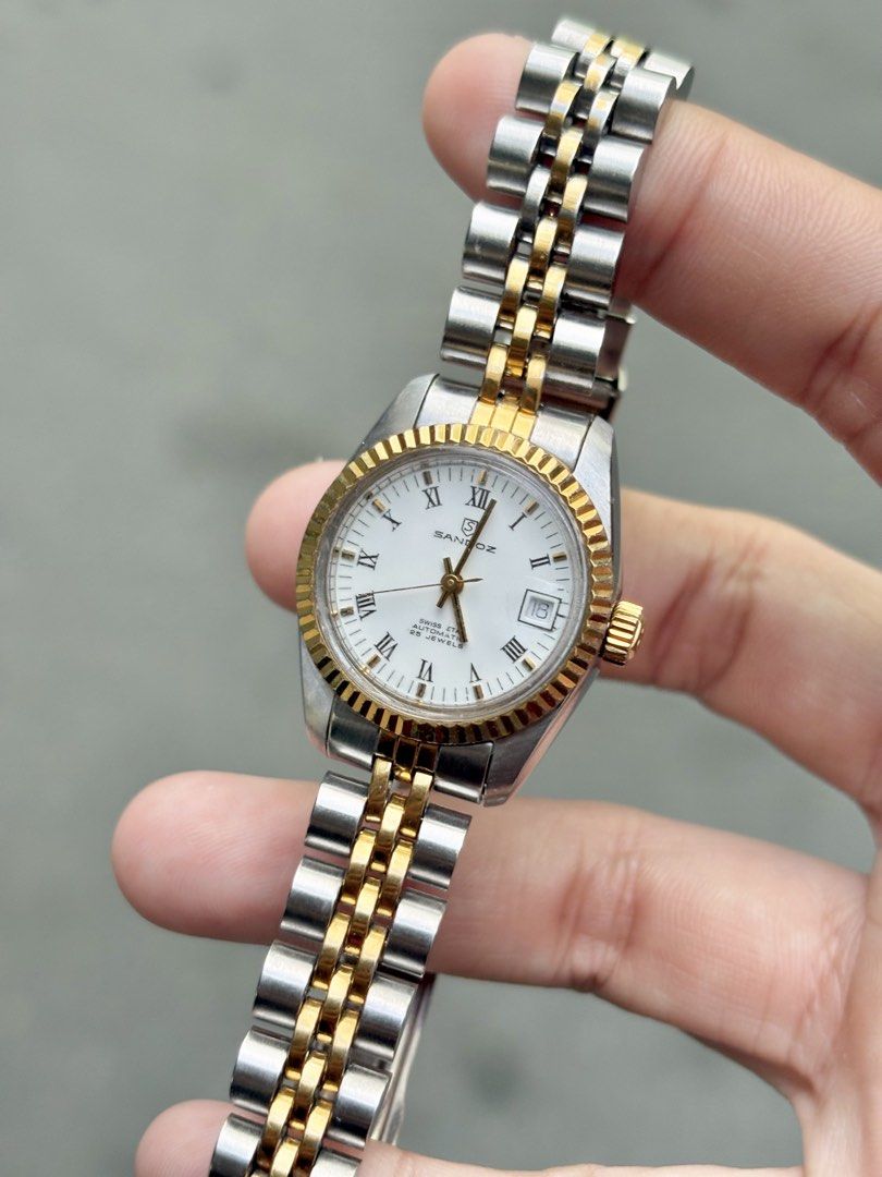 [Vintage] Sandoz Ladies Datejust Two-Tone Automatic (Category: Women's Watches) located in Bulacan. Submitted by whatsonyourwristmnl (Listing ID 1469193994, Image 2). Description: [VINTAGE] Sandoz Swiss Automatic Two-Tone Datejust Ladies Elegant vintage timepiece featuring a white Roman numeral dial, gold-tone fluted bezel, date display, and automatic movement with exhibition caseback. 🗓️ Birth Year: Exact year unconfirmed 📏 Case Size: Approx. 