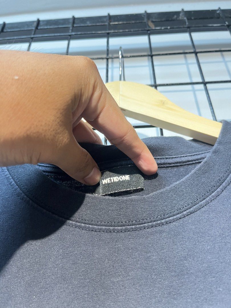 We11done Multi Logo Black T-Shirt (Category: Tshirts & Polo Shirts ) located in Taal. Submitted by thrift_deals23 (Listing ID 1469184387, Image 3). Description: - Brand: We11done - Color: Black with multi-colored stacked logo graphics on the front - Material: Premium heavy cotton - Fit: Standard relaxed fit, short sleeves - Authenticity: Includes brand collar label and authentication QR code tag near the hem - Condition: Minimal wear around the c