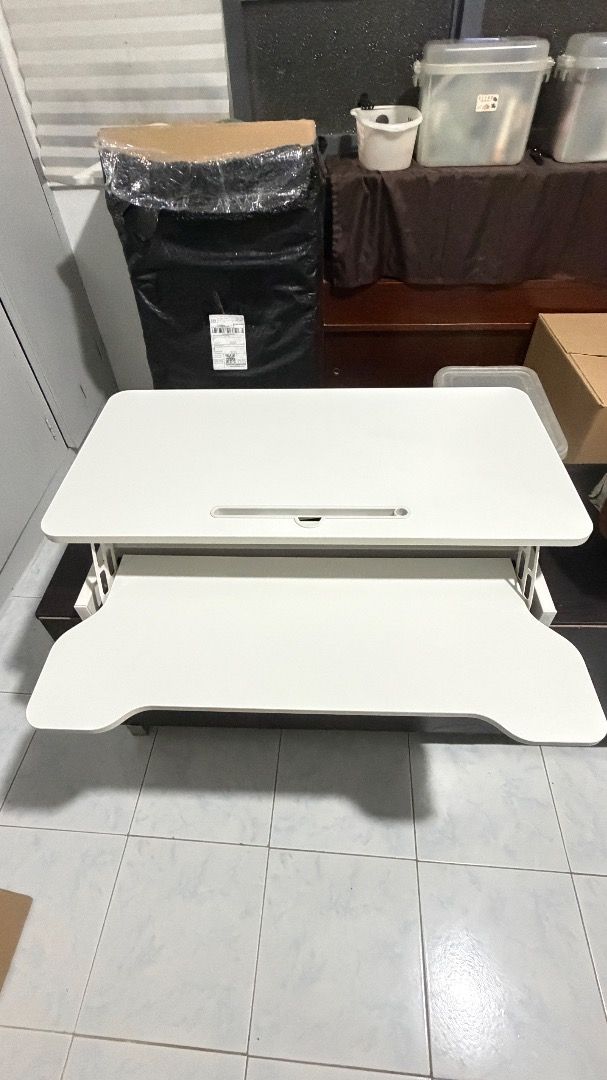 White adjustable desk/table riser (Category: Office Furniture & Fixtures) located in Quezon City. Submitted by roseyfinds (Listing ID 1469217031, Image 2). Description: Move-out sale. White 2-level desktop riser Looks good as new. Pick-up only via Lalamove or by buyer..
