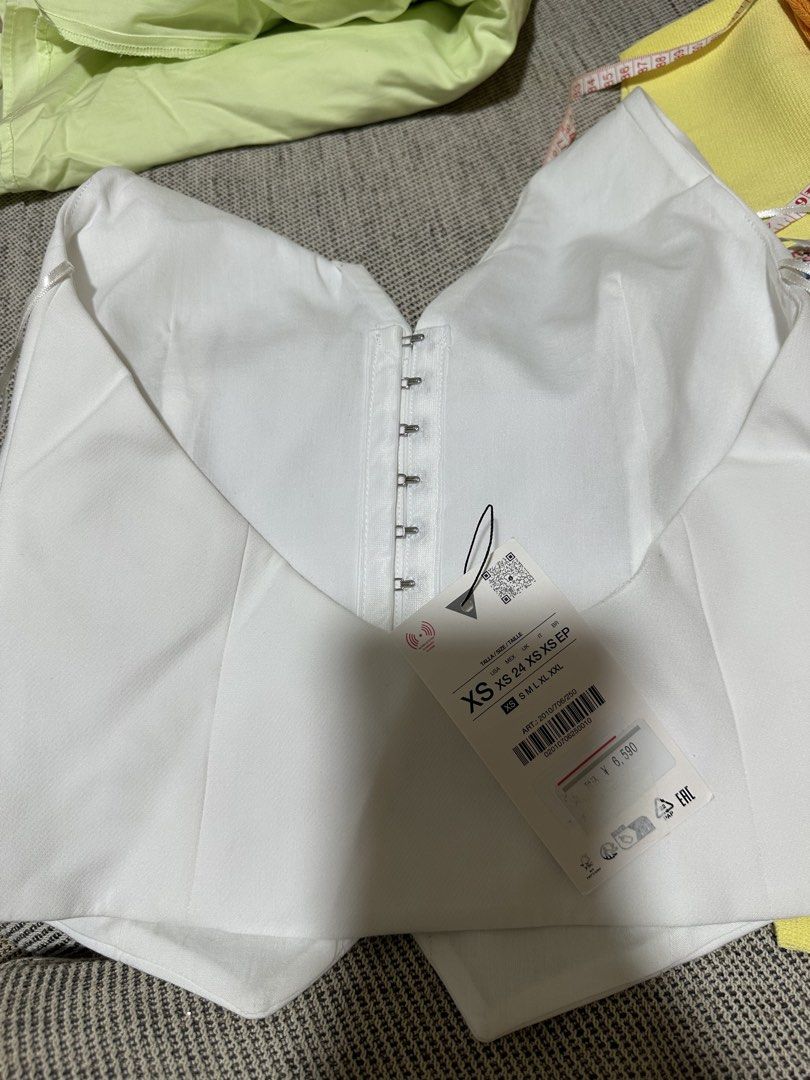 White Halter Vest with Floral Tie Strap (Category: Sleeveless) located in Cainta. Submitted by qualityyetaffordable (Listing ID 1469172741, Image 3). Description: - Condition: Brand new with original retail tags - Size: XS - Color/Style: White halter-style vest top with structured tailoring - Details: Piped front pockets and a distinctive floral patterned fabric tie strap at the neck - Closure: Secure hook-and-eye fastenings at the back.