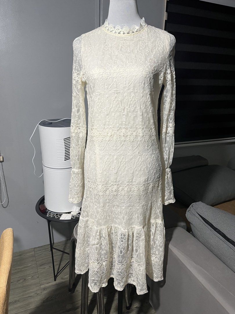 White Lace Long Sleeve Midi Dress (Category: Dresses) located in Manila. Submitted by madfitzz (Listing ID 1469312596, Image 1). Description: - Style: White lace midi dress with detailed floral pattern - Design: High neckline, long sleeves with slight flare at cuffs, and a ruffled hem - Comfort: Fully lined structure for a comfortable fit - Versatility: Ideal for parties, dinners, or casual-chic events - Footwear: Easy to style with both heels an