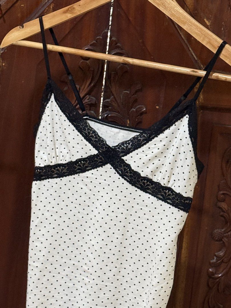 White Polka Dot Cami with Black Lace Trim (Category: Sleeveless) located in Iloilo. Submitted by wornwellco (Listing ID 1469165897, Image 3). Description: - Style: 90s Y2K aesthetic - Design: White with tiny black polka dots and black lace X-trim across the chest - Straps: Thin and adjustable - Fit: Body-hugging, stretchy cotton-blend fabric - Condition: Great overall condition.