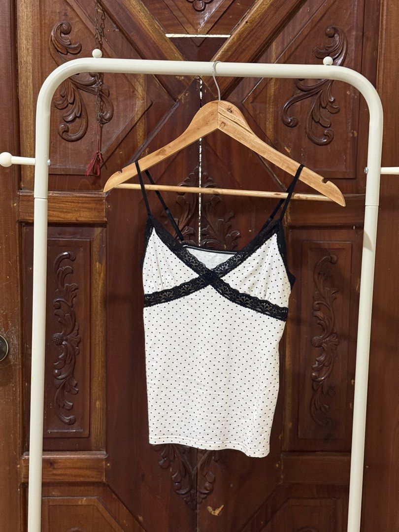 White Polka Dot Cami with Black Lace Trim (Category: Sleeveless) located in Iloilo. Submitted by wornwellco (Listing ID 1469165897, Image 2). Description: - Style: 90s Y2K aesthetic - Design: White with tiny black polka dots and black lace X-trim across the chest - Straps: Thin and adjustable - Fit: Body-hugging, stretchy cotton-blend fabric - Condition: Great overall condition.