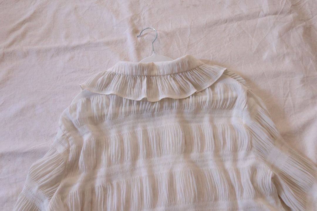 White Ruffle Collar Button-Down Blouse Long Sleeve (Category: Blouses) located in Manila. Submitted by imama23 (Listing ID 1469197311, Image 3). Description: - Color: White - Style: Vintage-inspired button-down blouse with textured pleated panels - Details: Large statement ruffle collar, flared cuffs, and front button closure - Fabric: Lightweight and slightly sheer Condition: 8/10 Size: M-L Location: Manila (near taft) 📦 SHIPPING • Full payment