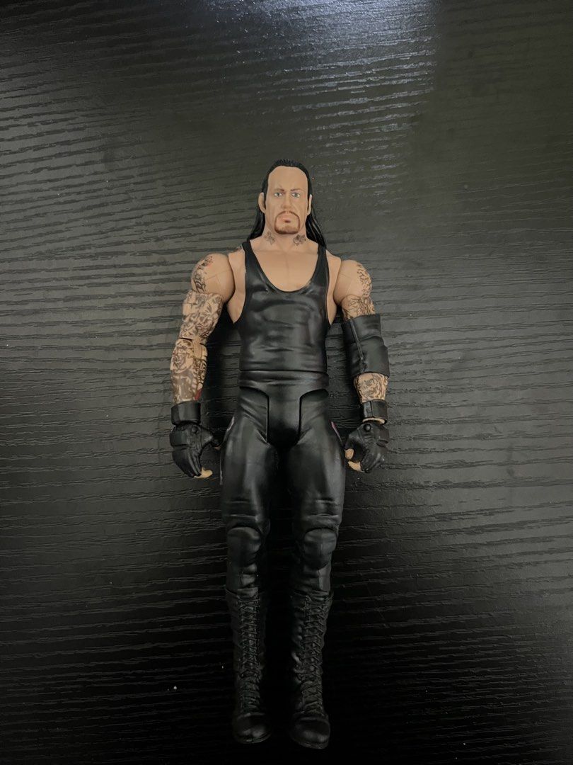 WWE Mattel The Undertaker Action Figure (Category: Figurines & Statues) located in Manila. Submitted by shoptoji (Listing ID 1469277747, Image 1). Description: - WYSIWYG , pm for more pics - Character: The Undertaker - Size: Approx. 7 inches tall - Condition: Loose figure, without original packaging - Details: Long black hair, goatee, and extensive arm tattoos - Attire: Black singlet, black pants, gloves, and boots - Articulation: Fully articulat