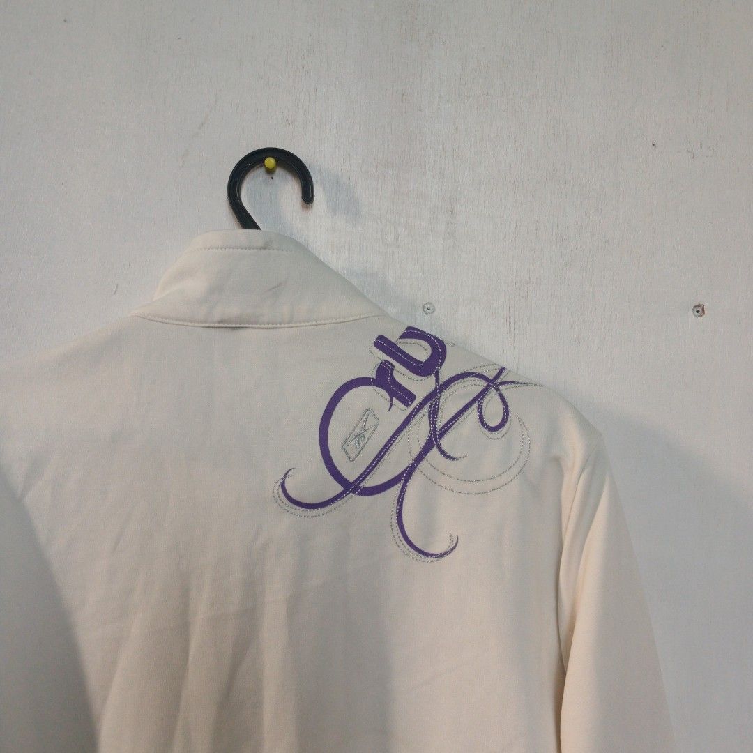 Y2K-era Reebok track jacket (Category: Coats, Jackets and Outerwear) located in Manila. Submitted by joefrey12 (Listing ID 1469238622, Image 3). Description: - Authentic white Reebok track jacket - Dimes 21x24.5 - Eye-catching purple glitter piping on sleeves and chest - Contrast dark navy cuffs and collar trim - Purple RBK embroidered logo on right chest with fancy silver-stitched RBK embroidery near the left shoulder - Full front zip closure wi
