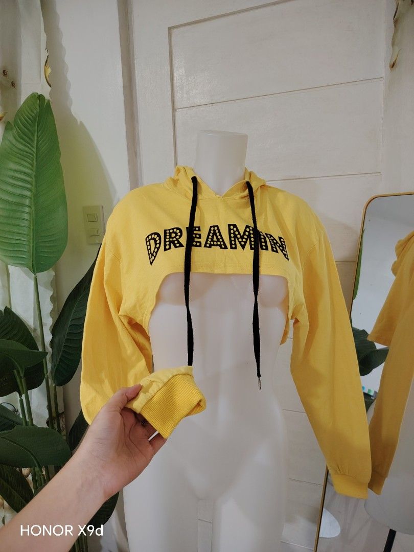 Yellow Crop Hoodie (Category: Coats, Jackets and Outerwear) located in Mabalacat. Submitted by Jackikay.PreLoved (Listing ID 1469296445, Image 2). Description: - Color: Bright yellow with black drawstrings - Design: 'DREAMIN' text printed across the front - Fit: Super short crop jacket ( long sleeves and ribbed cuffs ) - Material: Lightweight fabric, ideal for layering over tanks or bralettes - Size: 170 (fits like a standard women's cropped fit)