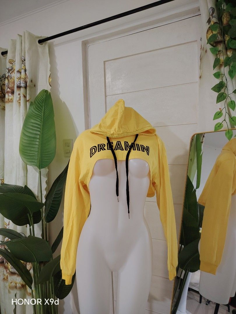 Yellow Crop Hoodie (Category: Coats, Jackets and Outerwear) located in Mabalacat. Submitted by Jackikay.PreLoved (Listing ID 1469296445, Image 1). Description: - Color: Bright yellow with black drawstrings - Design: 'DREAMIN' text printed across the front - Fit: Super short crop jacket ( long sleeves and ribbed cuffs ) - Material: Lightweight fabric, ideal for layering over tanks or bralettes - Size: 170 (fits like a standard women's cropped fit)
