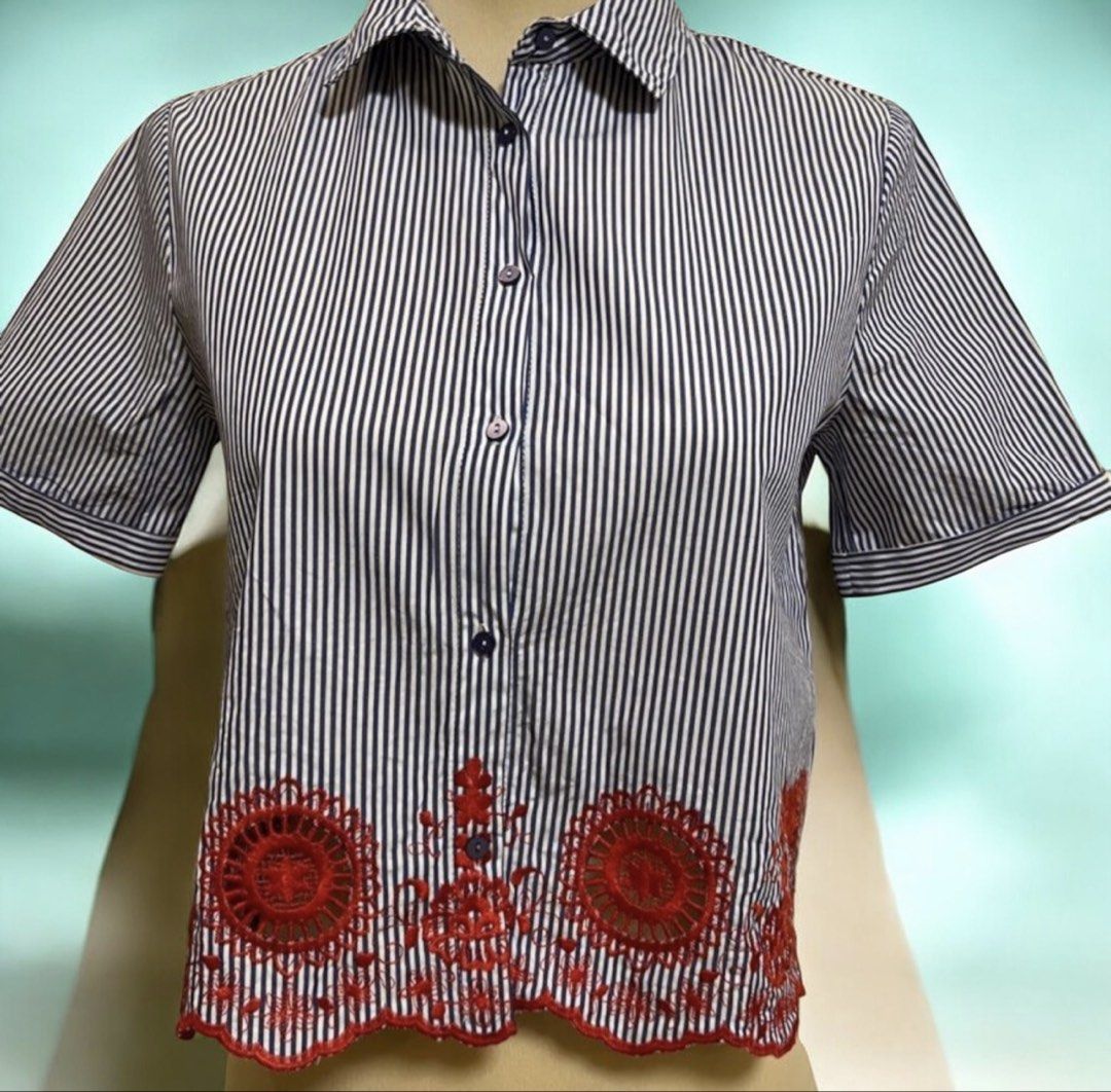Zara Basic Blue White Striped Embroidered Short Sleeve Shirt (Category: Shirts) located in Quezon City. Submitted by letsdeclutter101 (Listing ID 1469380854, Image 1). Description: - Brand: Zara Basic - Size: Small (S) - Design: Blue and white vertical stripes - Features: Short sleeves with folded cuffs, collared neck, front button closure - Detail: Red embroidered cut-out detail along the scalloped hemline.