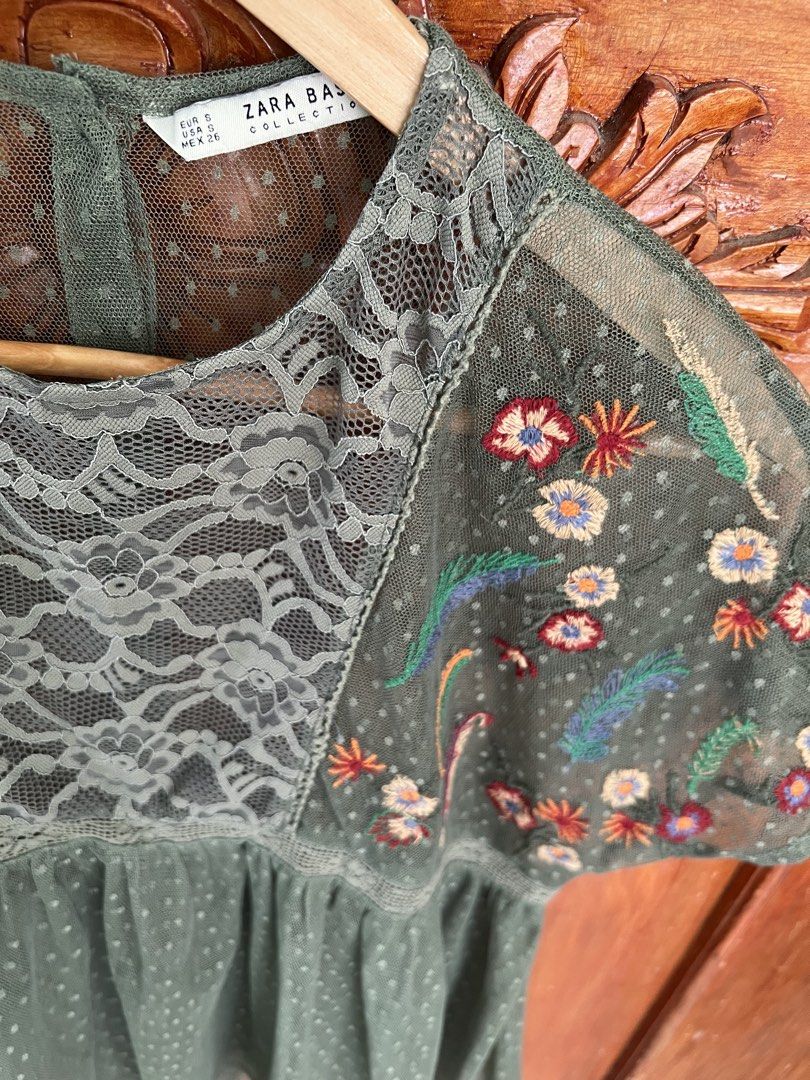 Zara Basic Collection Olive Green Embroidered Mesh Blouse Size S (Category: Blouses) located in San Fernando. Submitted by prettyfinds2021 (Listing ID 1469302942, Image 2). Description: - Brand: Zara Basic Collection - Size: Small (EUR S, USA S, MEX 26) - Color: Olive green - Material: Lightweight sheer mesh with dot pattern - Details: Floral embroidered short sleeves, front lace panel, round neckline with back button closure.