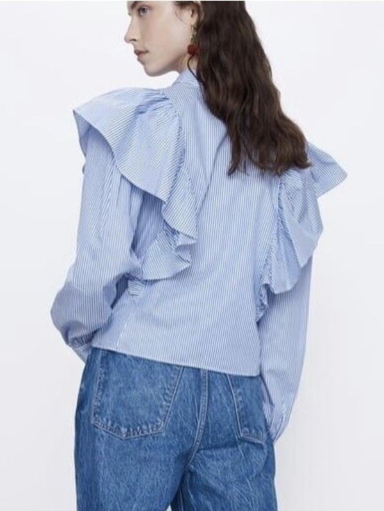 ZARA Blue White Striped Ruffled Blouse (Category: Blouses) located in General Santos City (Dadiangas). Submitted by amzonshop (Listing ID 1469241511, Image 2). Description: - Color/Pattern: Blue and white vertical stripes - Design: Dramatic oversized ruffled shoulders and matching front placket ruffles - Fit: Cropped length, ideal for high-waisted denim - Details: Classic pointed collar and buttoned cuffs - Material: Lightweight cotton blend with