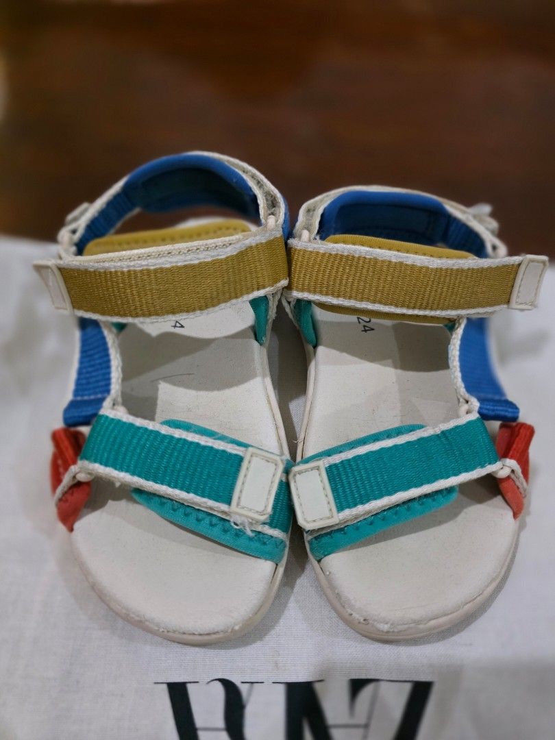 Zara Kids Multicolour Sandals Size 24 (Category: Babies & Kids Fashion) located in Quezon City. Submitted by sec0nd.st0ry (Listing ID 1469233507, Image 2). Description: - Brand: Zara Kids - Size: 24 (marked on footbed and outsole) - Design: Fun multicolour strap design - Closure: Secure hook-and-loop velcro closures across the front and ankle - Condition: White soles have minor dirt marks from previous wear with light scuffing underneath - Perfec
