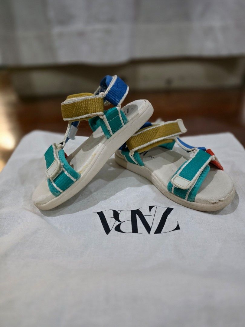 Zara Kids Multicolour Sandals Size 24 (Category: Babies & Kids Fashion) located in Quezon City. Submitted by sec0nd.st0ry (Listing ID 1469233507, Image 1). Description: - Brand: Zara Kids - Size: 24 (marked on footbed and outsole) - Design: Fun multicolour strap design - Closure: Secure hook-and-loop velcro closures across the front and ankle - Condition: White soles have minor dirt marks from previous wear with light scuffing underneath - Perfec