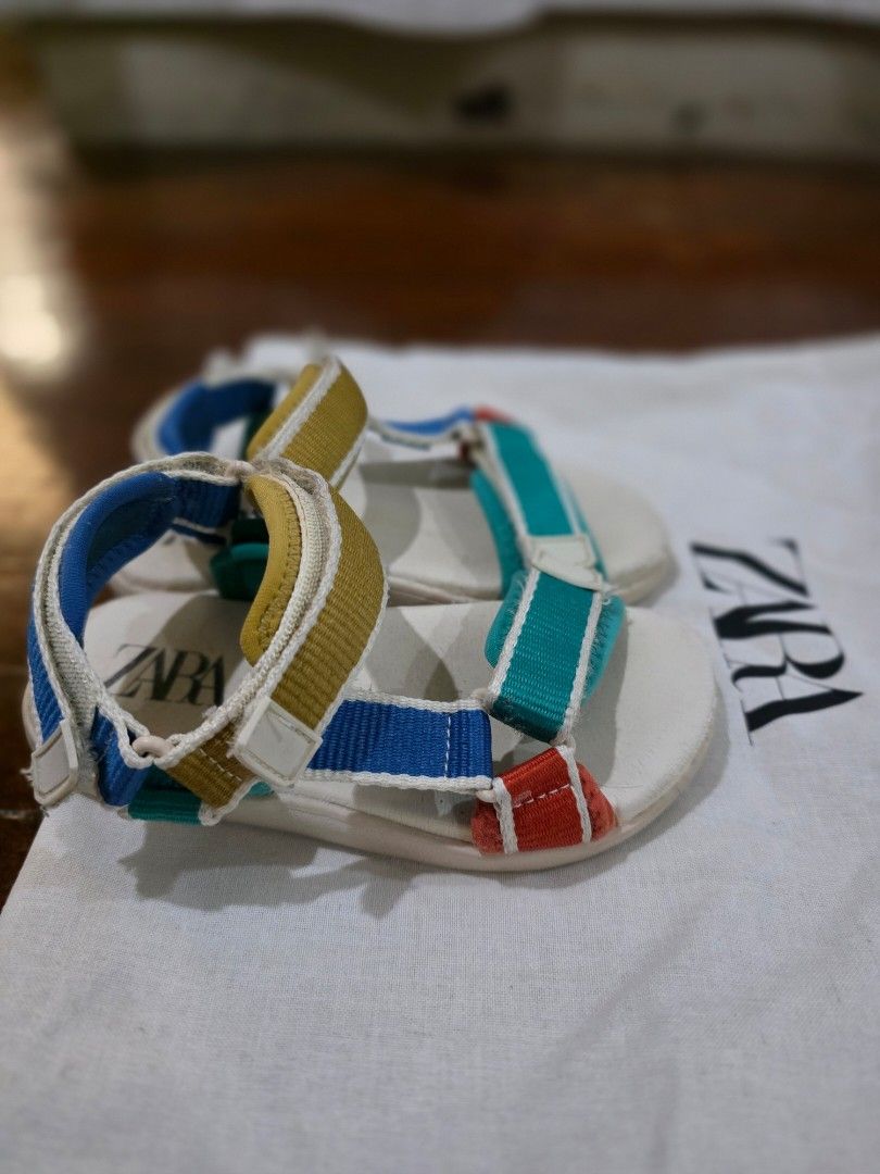 Zara Kids Multicolour Sandals Size 24 (Category: Babies & Kids Fashion) located in Quezon City. Submitted by sec0nd.st0ry (Listing ID 1469233507, Image 3). Description: - Brand: Zara Kids - Size: 24 (marked on footbed and outsole) - Design: Fun multicolour strap design - Closure: Secure hook-and-loop velcro closures across the front and ankle - Condition: White soles have minor dirt marks from previous wear with light scuffing underneath - Perfec