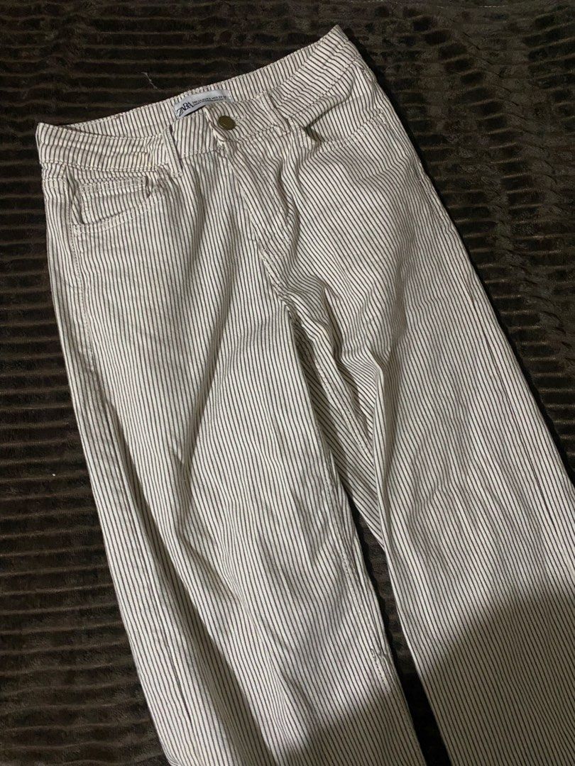 Zara Striped Pants (Category: Jeans) located in Iloilo. Submitted by luckyeagle_1c5618 (Listing ID 1469295790, Image 1). Description: - Brand: Zara - Style: Classic straight leg pants - Color/Pattern: White with thin black vertical stripes - Closure: Standard button and zipper - Condition: Clean fabric with minimal wear - Versatile neutral piece, pairs easily with any basic top.