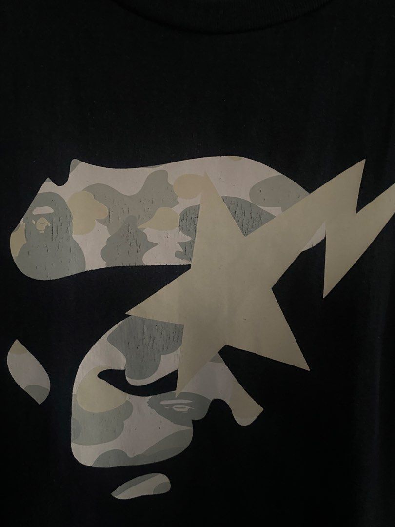 A Bathing Ape Bape Camo Sta T-Shirt (Category: Tshirts & Polo Shirts ) located in Manila. Submitted by upcycleutopia_ (Listing ID 1469477428, Image 2). Description: - Brand: A Bathing Ape (BAPE) - Color: Black - Size: medium - Design: medium chest graphic with camo Bape head, lightning bolt sta, and bottom hem branding - Details: Small embroidered ape logo tag on sleeve cuff, classic crew neck, short sleeves - Condition: Pre-owned with some natur