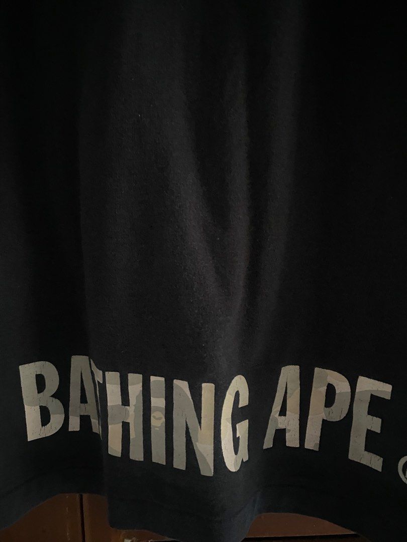 A Bathing Ape Bape Camo Sta T-Shirt (Category: Tshirts & Polo Shirts ) located in Manila. Submitted by upcycleutopia_ (Listing ID 1469477428, Image 3). Description: - Brand: A Bathing Ape (BAPE) - Color: Black - Size: medium - Design: medium chest graphic with camo Bape head, lightning bolt sta, and bottom hem branding - Details: Small embroidered ape logo tag on sleeve cuff, classic crew neck, short sleeves - Condition: Pre-owned with some natur