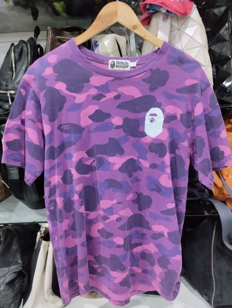 A Bathing Ape Purple Camo Tee Size L (Category: Tshirts & Polo Shirts ) located in Manila. Submitted by niggzreyno51476 (Listing ID 1469441766, Image 1). Description: - Brand: A Bathing Ape (BAPE) - Design: All-over purple and pink camo with white ape head chest graphic - Size: L (Regular fit) - Material: Comfortable cotton knit fabric - Details: Classic collar tag and authentic secondary tag on the sleeve hem - Condition: 100% authentic, well-ma