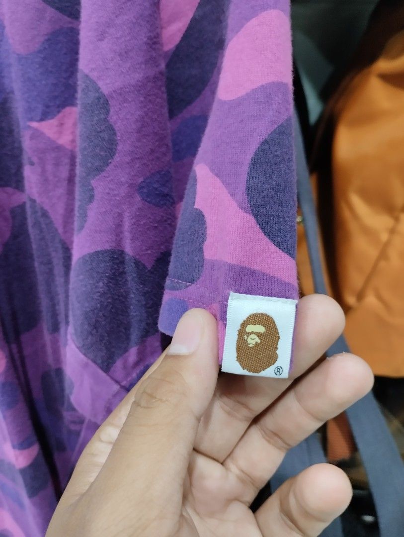 A Bathing Ape Purple Camo Tee Size L (Category: Tshirts & Polo Shirts ) located in Manila. Submitted by niggzreyno51476 (Listing ID 1469441766, Image 2). Description: - Brand: A Bathing Ape (BAPE) - Design: All-over purple and pink camo with white ape head chest graphic - Size: L (Regular fit) - Material: Comfortable cotton knit fabric - Details: Classic collar tag and authentic secondary tag on the sleeve hem - Condition: 100% authentic, well-ma