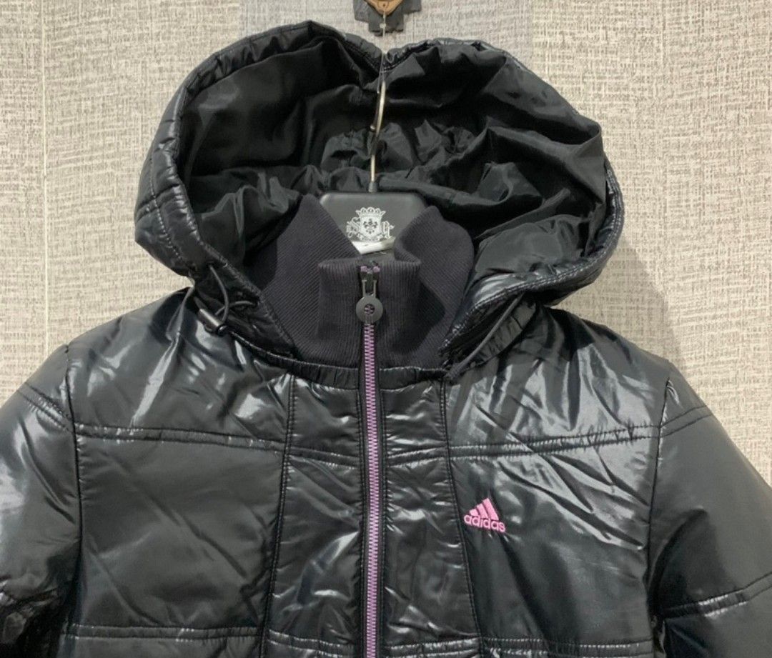 Adidas Black Puffer Jacket with Hood (Category: Coats, Jackets and Outerwear) located in Quezon City. Submitted by cuteitemsonlyyy (Listing ID 1469448306, Image 1). Description: - Brand: Adidas - Color: Black with pink embroidered logo and purple-toned zipper - Material/Design: Shiny quilted padded finish - Features: Full zip front, attached hood with drawstrings, high ribbed collar - Comfort: Ribbed cuffs and hem to block out the wind - Conditio
