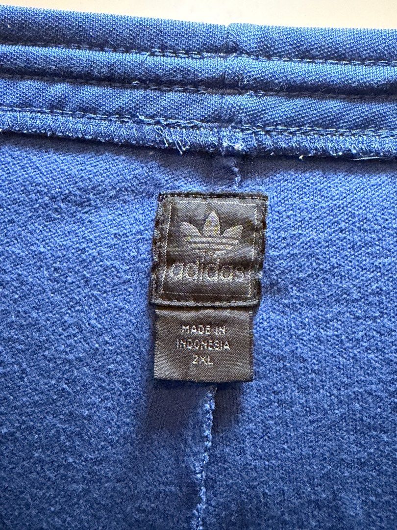Adidas Blue Track Pants Size 2XL (Category: Joggers) located in Manila. Submitted by swiftgem.eeb06e (Listing ID 1469515492, Image 3). Description: - Brand/Style: Classic blue Adidas track pants with iconic white side stripes - Size: 2XL (Made in Indonesia) - Material: Comfortable cotton and polyester blend - Features: Adjustable drawstring waist and secure front zip pockets - Condition: Great for casual wear or workouts - Size: 2XL - Dims: 19 x 