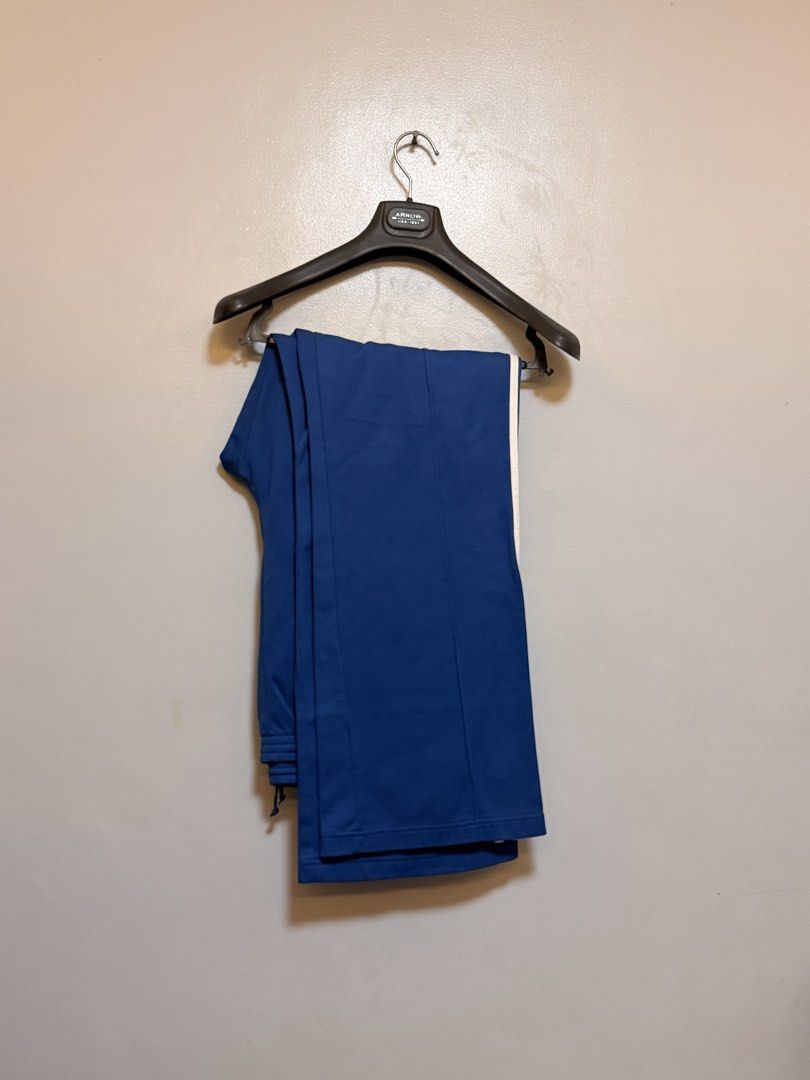 Adidas Blue Track Pants Size 2XL (Category: Joggers) located in Manila. Submitted by swiftgem.eeb06e (Listing ID 1469515492, Image 2). Description: - Brand/Style: Classic blue Adidas track pants with iconic white side stripes - Size: 2XL (Made in Indonesia) - Material: Comfortable cotton and polyester blend - Features: Adjustable drawstring waist and secure front zip pockets - Condition: Great for casual wear or workouts - Size: 2XL - Dims: 19 x 