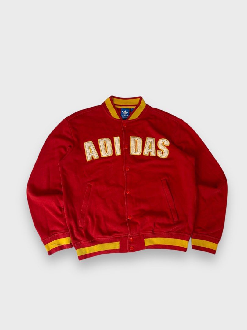 Adidas Red Yellow Varsity Jacket Size M (Category: Coats, Jackets and Outerwear) located in Calauan. Submitted by lancesuerte13 (Listing ID 1469455003, Image 1). Description: - Brand: Adidas - Style: Red varsity jacket with yellow ribbing on collar, cuffs, and hem - Design: Large white and yellow ADIAS lettering patch across the chest - Details: Button-up front closure with branded metal buttons, two front pockets - Authenticity: Features blue tr