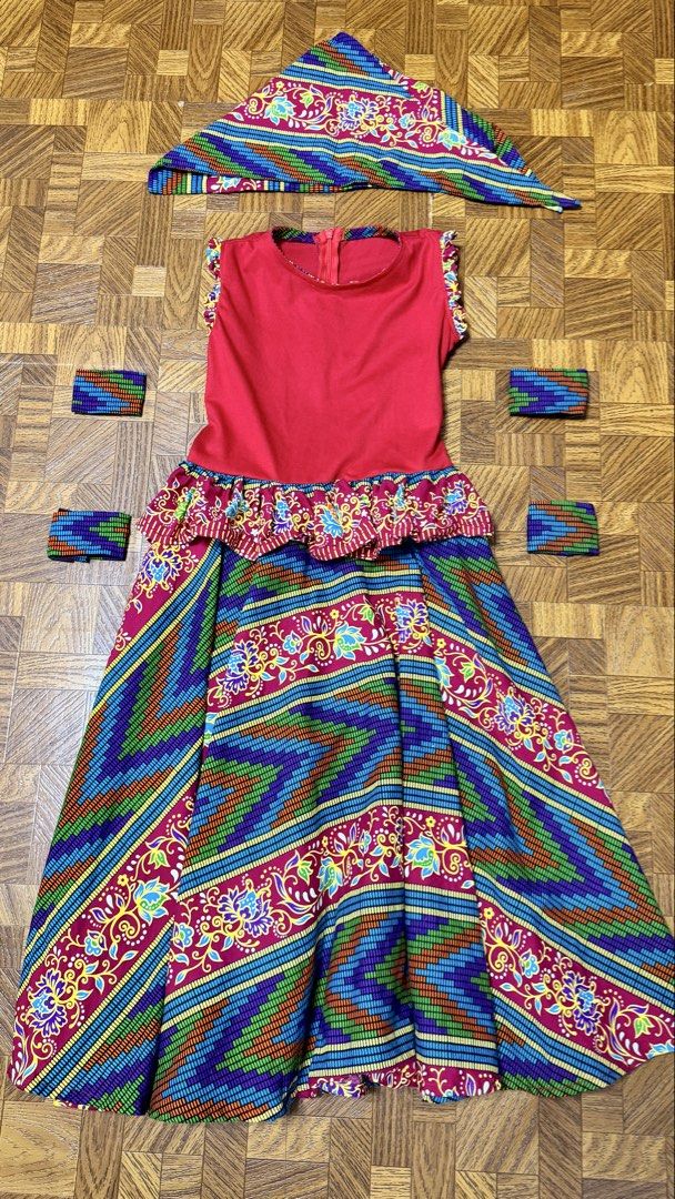 African Costume Set (Category: Babies & Kids Fashion) located in Quezon City. Submitted by frappes (Listing ID 1469441761, Image 1). Description: - Set includes: Red top, colorful patterned skirt, matching headscarf, and 4 arm cuffs - Condition: Worn only once for a performance - Features: Beautiful detailing around the shoulders and waist peplum - Perfect for: Stage shows, cultural events, or school dress-up days - Bright and eye-catching colors