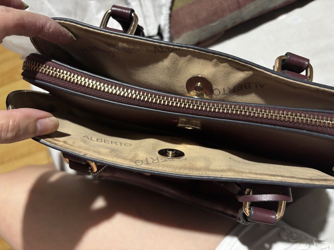 ALBERTO Maroon Handbag with Detachable Strap (Category: Shoulder Bags) located in Manila. Submitted by cleverdog_2c1729 (Listing ID 1469513188, Image 3). Description: - Brand: ALBERTO - Color: Maroon - Includes matching adjustable shoulder strap and cute character keychain - Secure main zipped compartment flanked by two open side sections with magnetic snap closures - Interior lining features printed ALBERTO branding - Elegant gold-tone hardware 