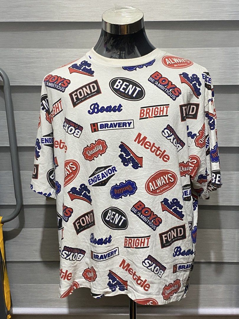 All-Over Graphic Print Oversized T-Shirt (Category: Tshirts & Polo Shirts ) located in Butuan. Submitted by nielben13 (Listing ID 1469570811, Image 1). Description: - Style: Bold streetwear graphic tee - Color: White with red, blue, and black text patches (BENT, BOYS, BRIGHT, FOND) - Fit: Relaxed crew neck, short sleeves - Condition: Need wash / Excellent - Mode of Payment: GCash - Shipping: Same-day delivery via J&T Express .