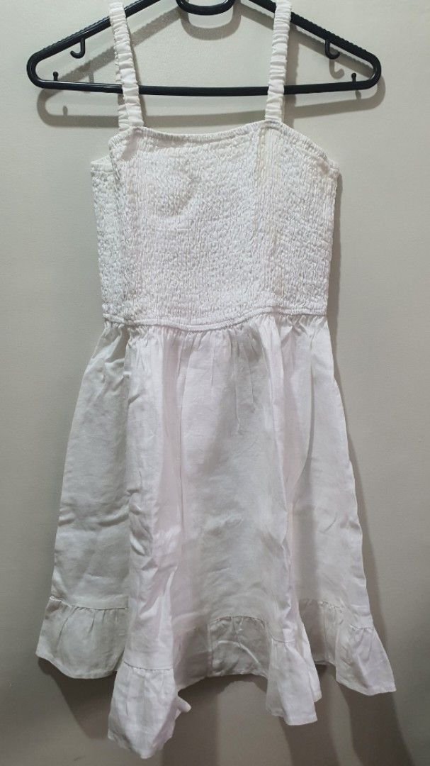 Ally White Smocked Dress Size 10 (Category: Babies & Kids Fashion) located in Santa Rosa. Submitted by regcruz (Listing ID 1469403822, Image 1). Description: - Brand: Ally Rustans - Size: 10 - Color: White - Style: Sleeveless dress with flared skirt - Details: Smocked bodice with textured fabric, includes shoulder straps - Condition: Clean, EUC, and ready to wear.