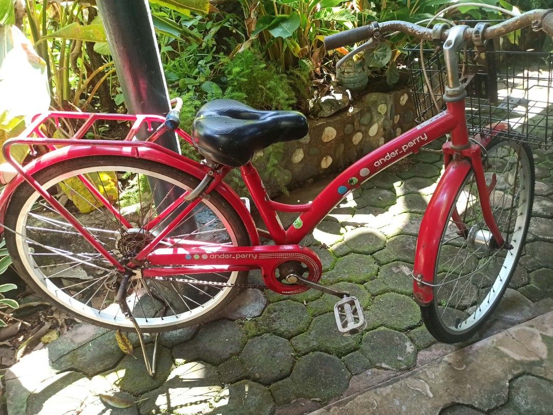 Ander Perry Red City Bicycle with Basket and Rack (Category: Bicycles) located in Caloocan City. Submitted by mojica032893 (Listing ID 1469568339, Image 2). Description: - Bright red Ander Perry city bike, perfect for daily commuting - Includes a convenient front wire basket and sturdy rear rack - Comfortable black saddle featuring a ventilation slot - Equipped with a reliable kickstand - Fully functional with minor surface wear on the frame and 