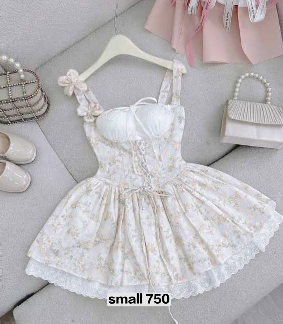 Anna Clothing Dress (Category: Dresses) located in Las Pinas. Submitted by lodss91453 (Listing ID 1469540373, Image 1). Description: - Style: White mini dress with soft floral print - Design: Sweetheart bust, ribbon straps, bow accents, and adjustable lace-up front - Details: Flared skirt with delicate lace hem and back zipper closure - Fit: Size Small - Occasion: Perfect for casual outings, dates, and weekend lakwatsas.