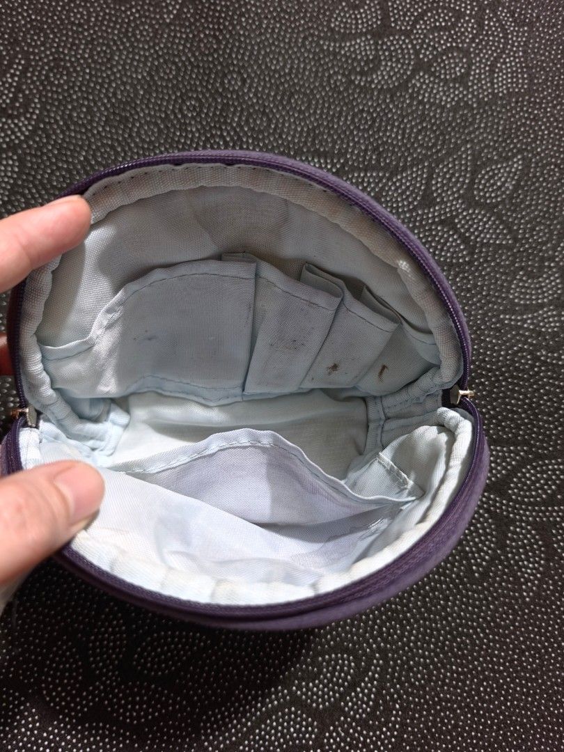 Anna Sui Purple Cosmetic Pouch (Category: Purses & Pouches) located in Manila. Submitted by gentlewind_91c54e (Listing ID 1469532413, Image 2). Description: - Brand: Anna Sui - Color: Purple with white embroidered logo - Closure: Double zip (protective plastic still on one pull tab) - Interior: Light blue fabric lining with pockets and slip compartments - Condition: Good exterior, with some stains and marks inside the lining from previous use - S
